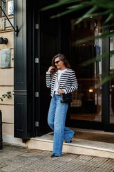 a lady wears a striped cardigan with a straight leg jeans